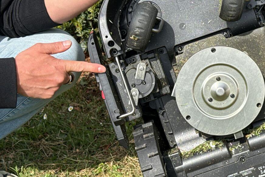 Der Roborock RockMow S1wird von unten gezeigt und man sieht das seitlich sitzende Randschnittmodul mit zwei Klingen